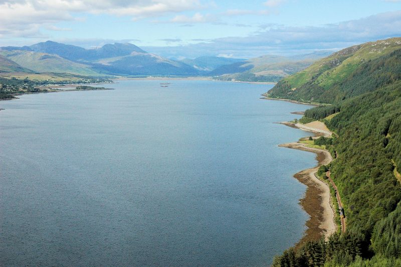 The railway journey from Inverness to Strathcarron and/or Kyle of Lochalsh on the Kyle Line is one of the most spectacular in the whole of the UK and passes through some magnificent Scottish Highland scenery. It featured in Michael Palin's BBC TV series as one of the Great Railway Journeys of the World. This photo shows the line hugging the coast along the south shore of Loch Carron.